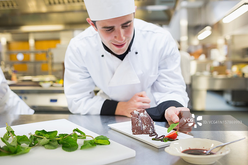 快乐的厨师用薄荷装饰甜点图片素材