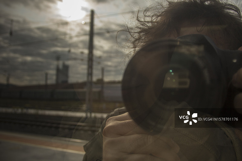男人在火车车窗上拍照的倒影图片素材