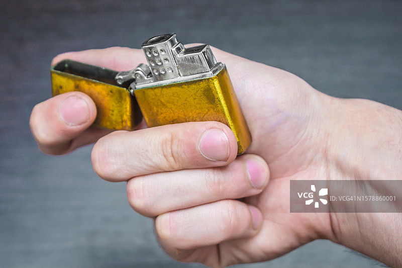 在黄色和蓝色调的深色背景上手工制作的金色打火机，乌克兰图片素材