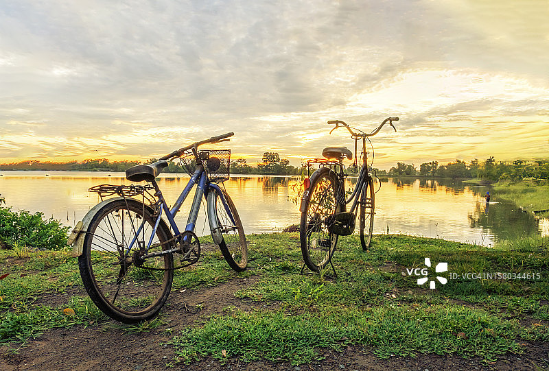 日出时停在湖边的自行车的背面视角图片素材