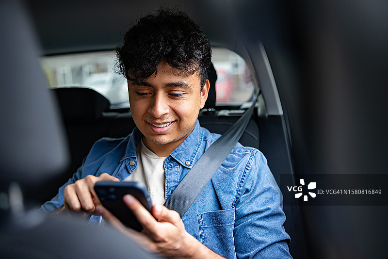 乘客乘坐网约车并用手机发短信图片素材