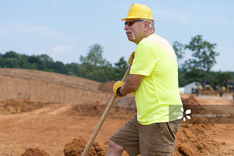 在道路施工现场用铲子的工人图片素材