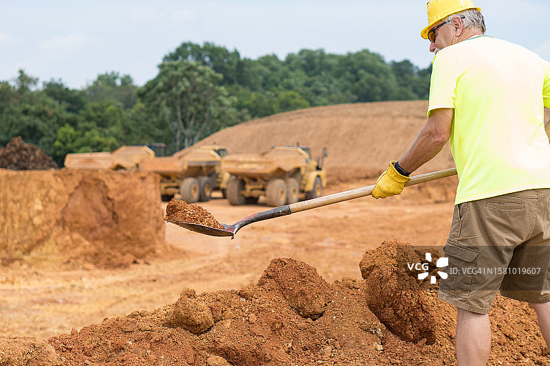 在道路施工现场用铲子的工人图片素材