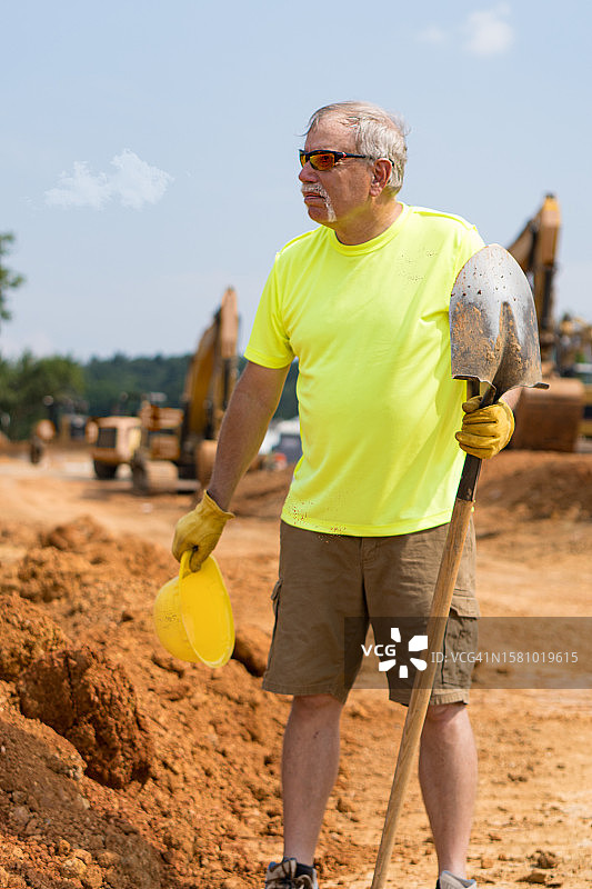 工人在道路施工现场用铲子暂停工作图片素材