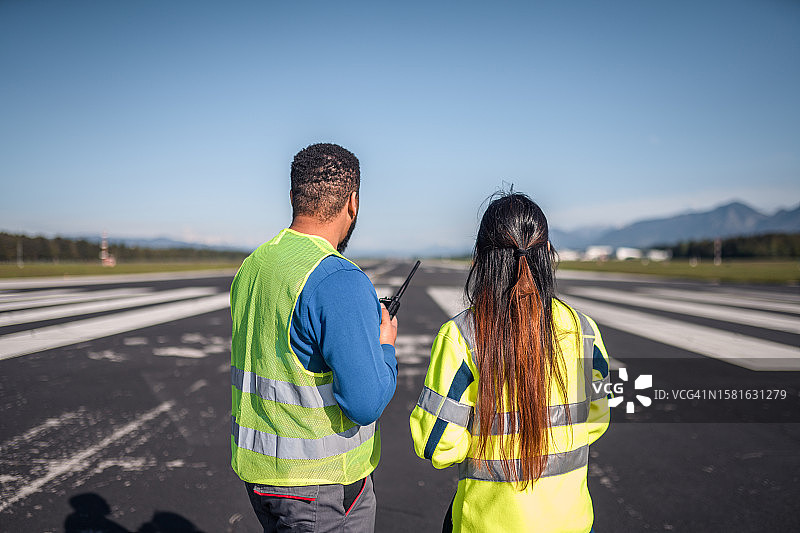 男性和女性机场运营人员监控和维护飞行记录图片素材