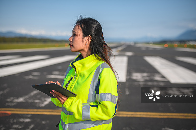 使用平板电脑的亚洲女性机场运营人员图片素材