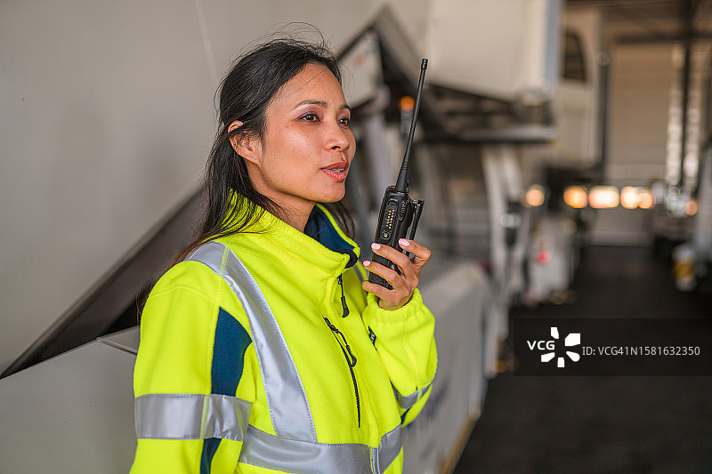 在舷梯旁的亚洲女机场工作人员图片素材