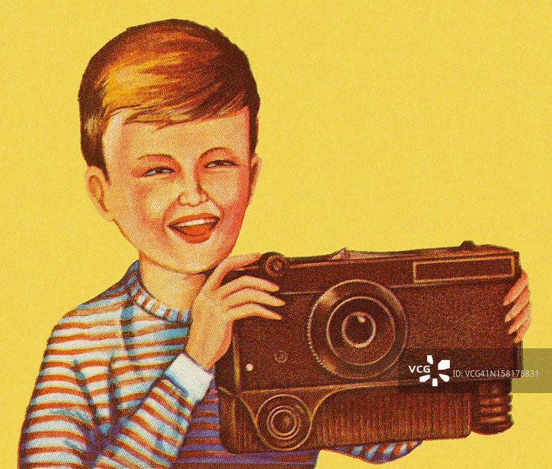 男孩拿着大型棕色相机图片素材