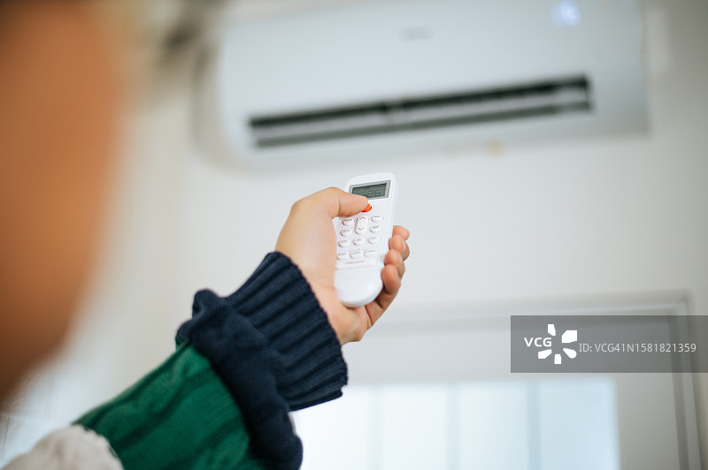 在家打开空调的亚洲男士肖像图片素材