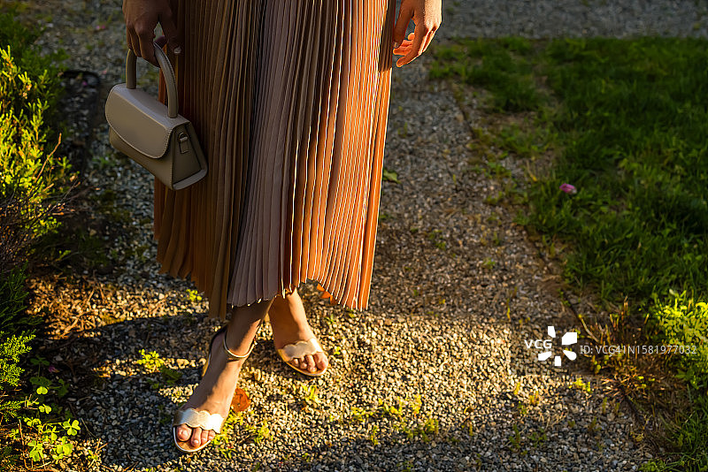 年轻的多种族女人穿着优雅的连衣裙和高跟鞋，拿着小钱包图片素材