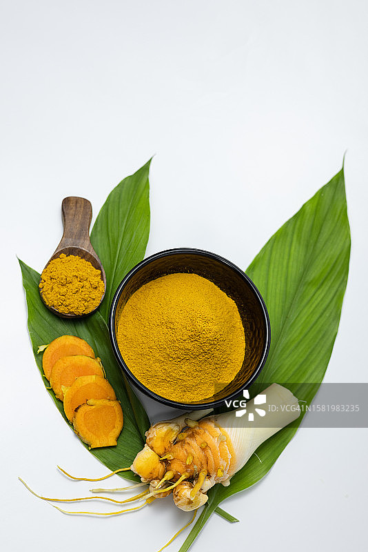 香料：白色背景下的姜黄根、姜黄粉和叶子图片素材