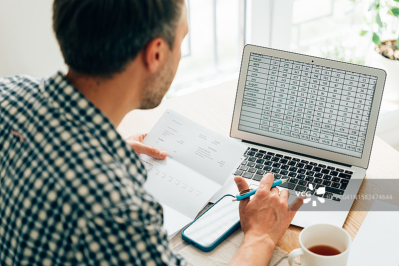 使用计算器分析财务数据的男人图片素材