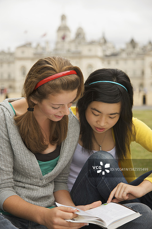 两个少女在伦敦皇家骑兵卫队阅兵场前读书图片素材