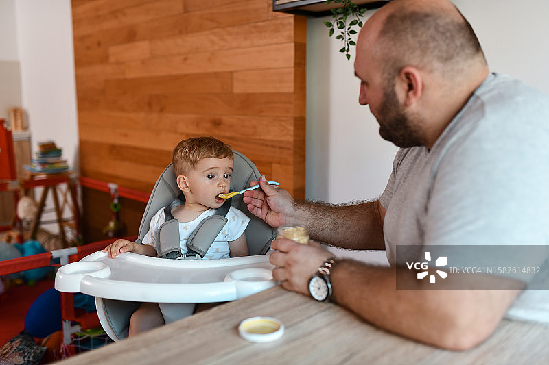 父亲在家喂宝宝吃麦片和水果泥图片素材