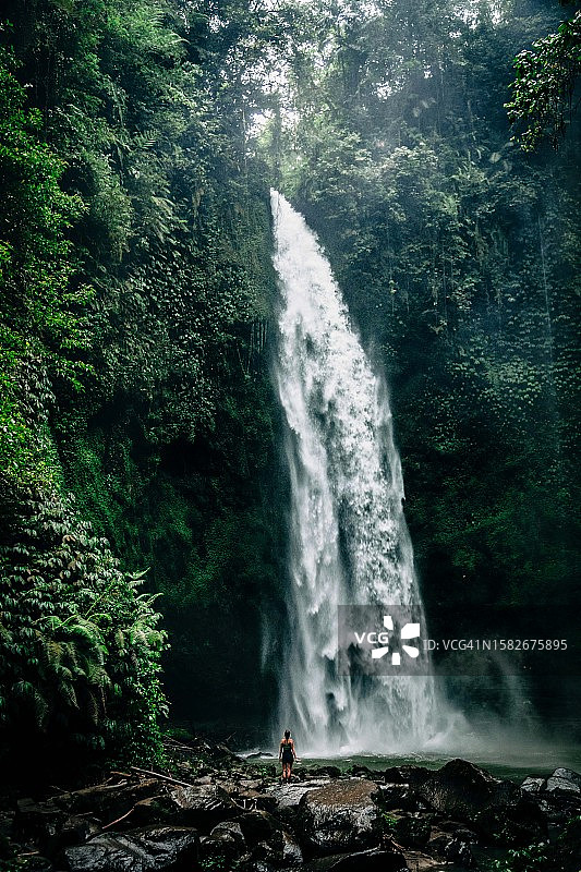 在巴厘岛瀑布玩耍的美丽女孩图片素材