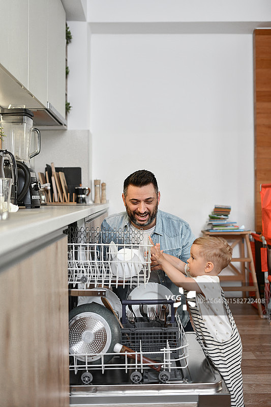 微笑的父亲在家为幼儿儿子培养健康的饮食习惯图片素材