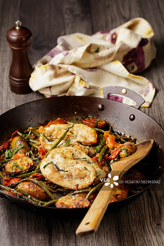 单盘烤鸡胸肉配蒜香小土豆、青豆和樱桃番茄图片素材