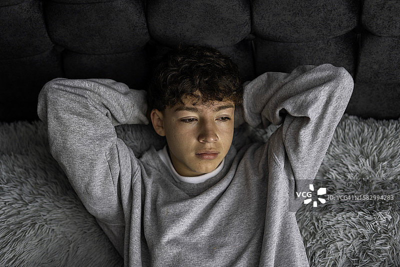 躺在床上心事重重的青少年男孩图片素材