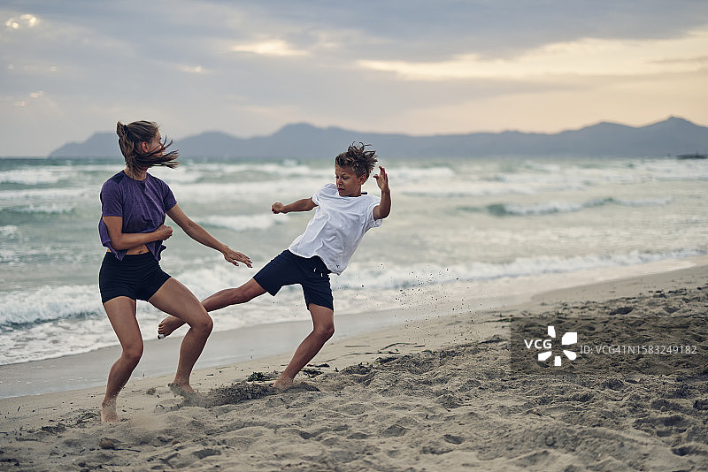 在海滩上练习空手道的少女和男孩图片素材
