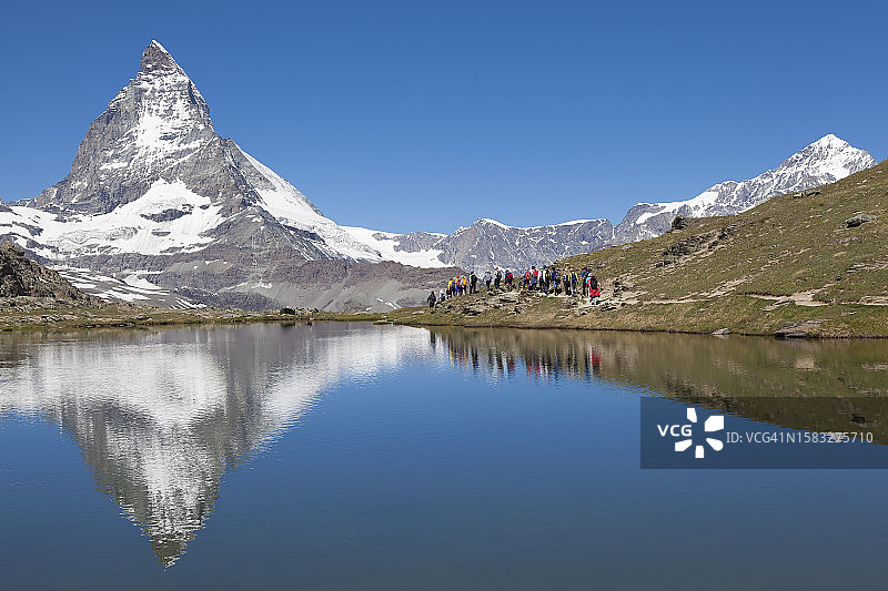 人们沿着策马特附近的里弗尔湖行走，背景是马特宏峰图片素材