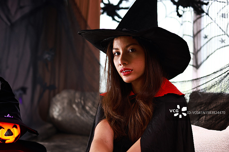 迷人的女巫在庆祝房间里参加万圣节派对，留白图片素材