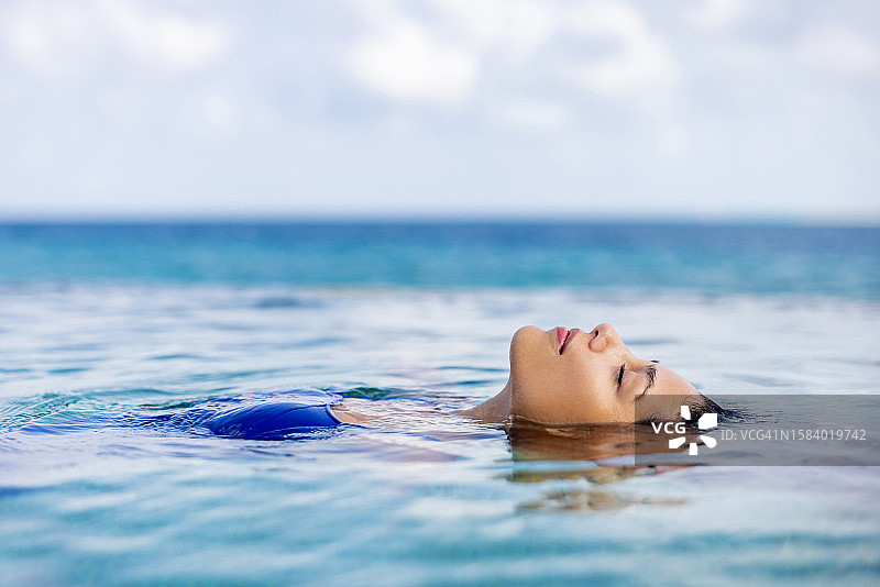 在游泳池中漂浮的美丽女人图片素材