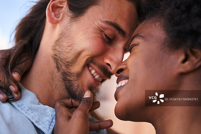 亲密依偎，笑容满面的多民族情侣图片素材