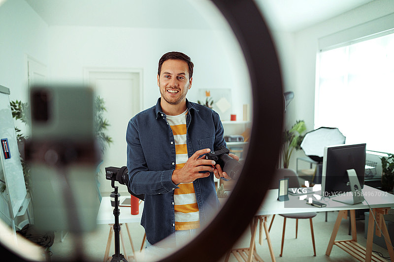 年轻英俊的男人拍摄数码单反相机视频图片素材