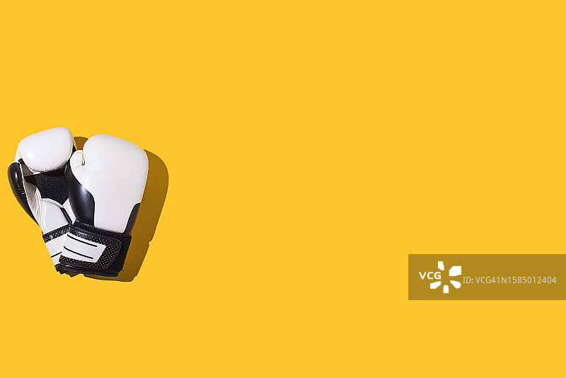 黄色背景上的黑白拳击手套图片素材