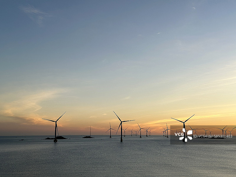 日出时分的海上风力发电场图片素材