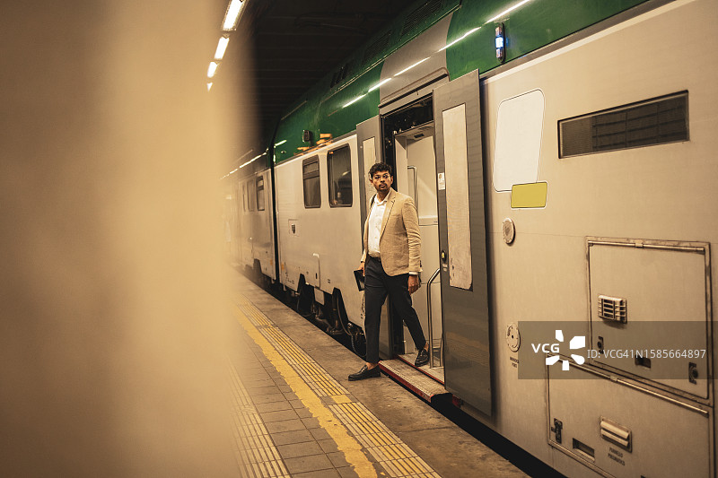 千禧一代印度商人通勤上班，在车站乘坐火车图片素材