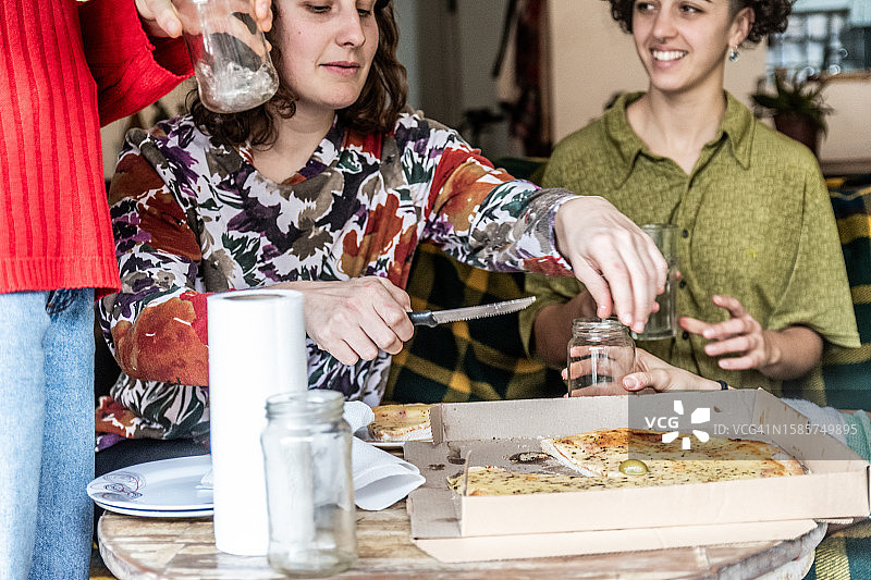 女性朋友在家吃披萨时聊天图片素材