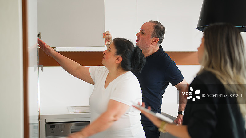 女房地产经纪人向已婚老年夫妇展示新房图片素材