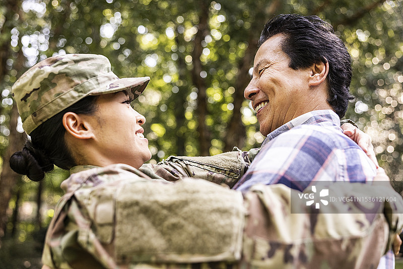 父亲拥抱女儿，女儿是穿2023年OCP制服的美国女兵图片素材