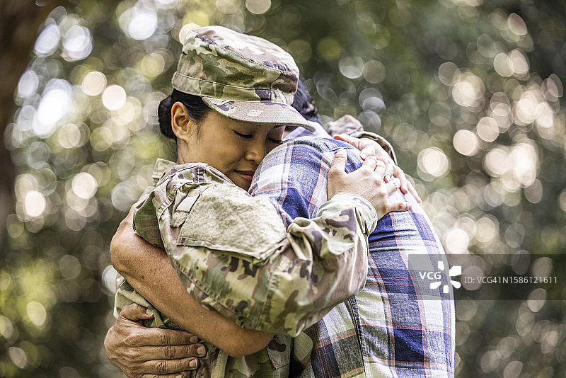 父亲拥抱女儿/穿2023 OCP制服的美国女兵在户外图片素材