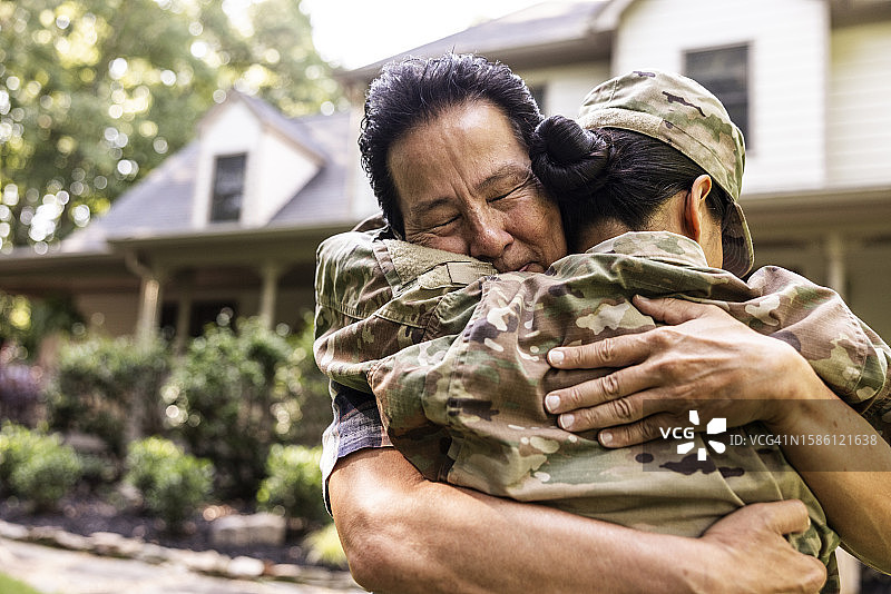 父亲拥抱女儿，女儿是穿2023年OCP制服的美国女兵图片素材