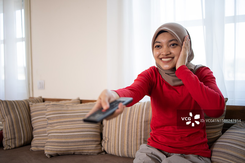女人在家里欣赏她最喜欢的电视节目图片素材