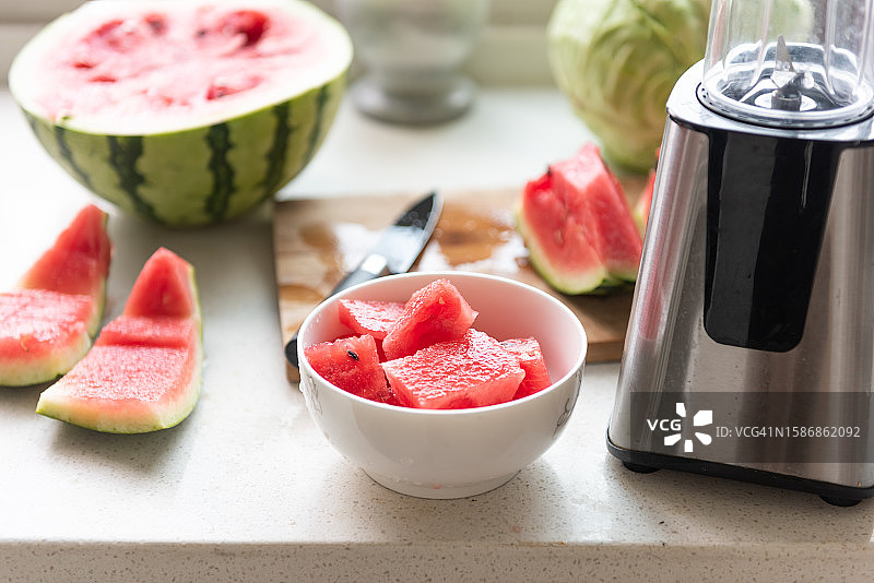 用搅拌器在家里做西瓜汁。室内自制健康的生活方式图片素材