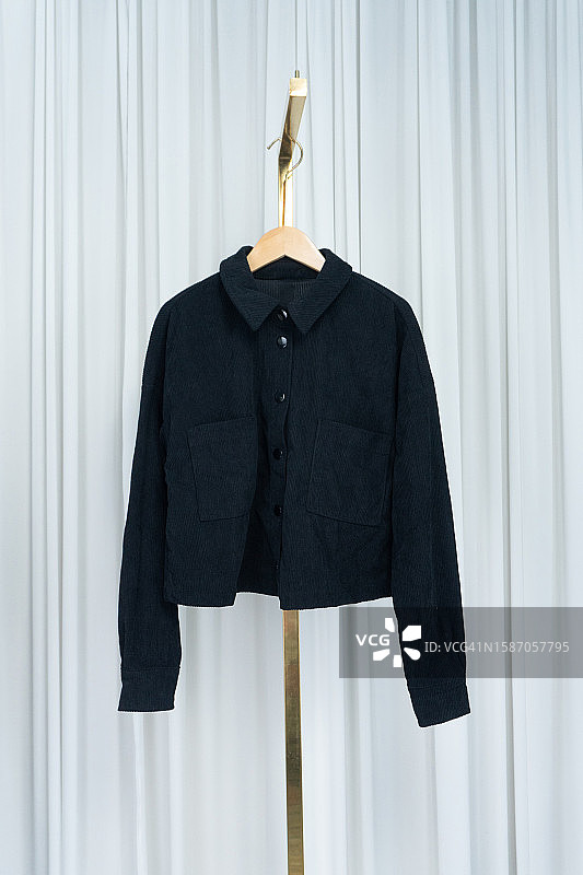现代衣柜：白色窗帘上展示的黑色夹克图片素材