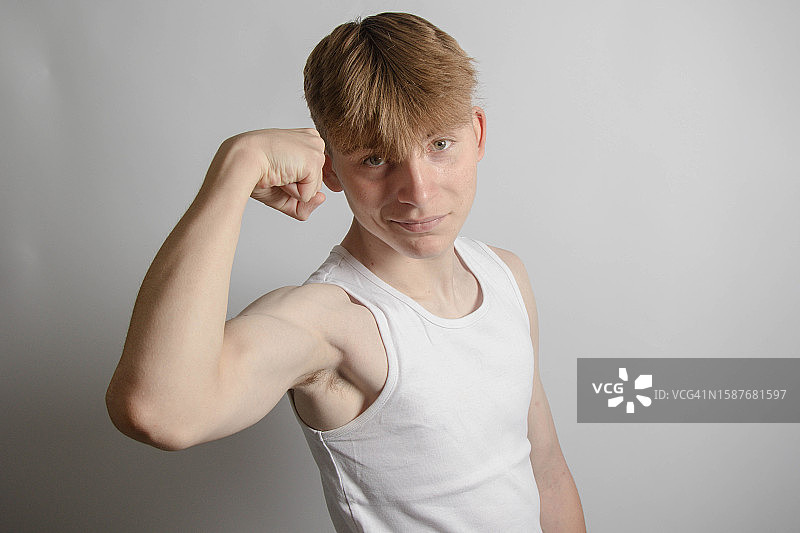 男子在英国伦敦灰色背景下展示肌肉的肖像图片素材