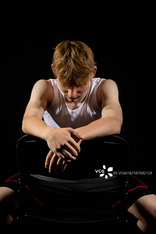 坐在英国伦敦黑色背景椅子上的年轻人图片素材