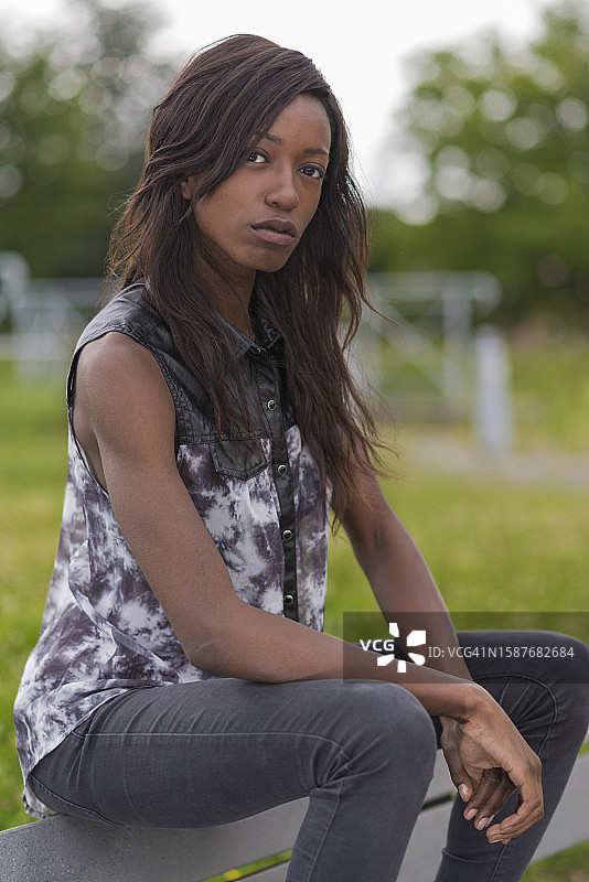 坐在长椅上的年轻女子的肖像图片素材