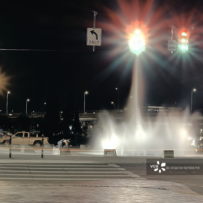 夜晚坐在喷泉旁的男人图片素材