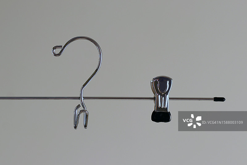 灰色背景上的金属衣架上的挂钩和夹子图片素材