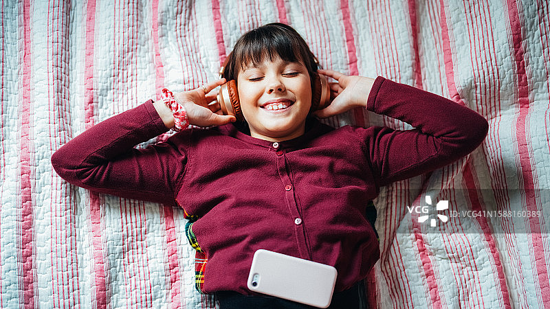 在床上听音乐的少女图片素材