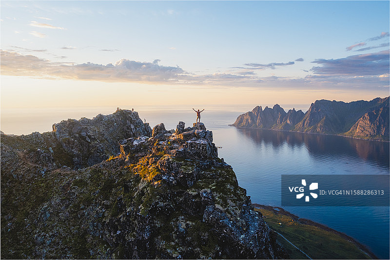 男子站在山顶俯瞰峡湾，挪威图片素材