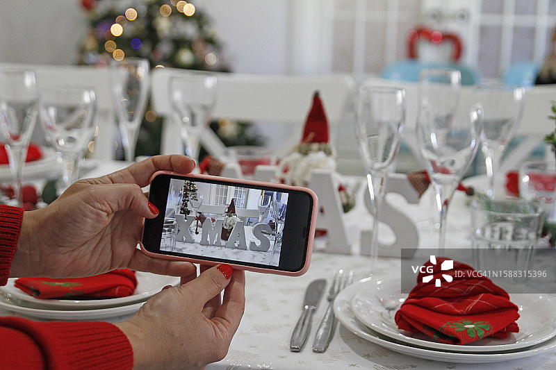 正在拍摄喜庆圣诞餐桌的女人图片素材