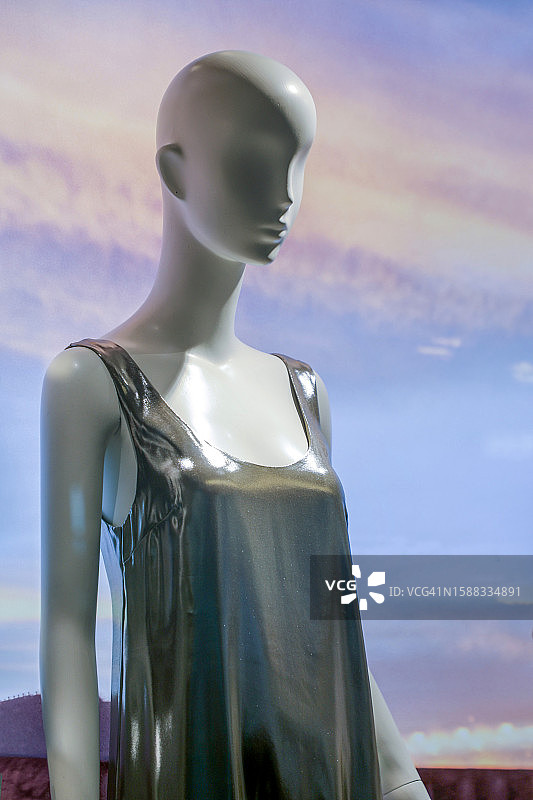 屏幕背景前穿着金属亮片连衣裙的变形女性人体模型图片素材