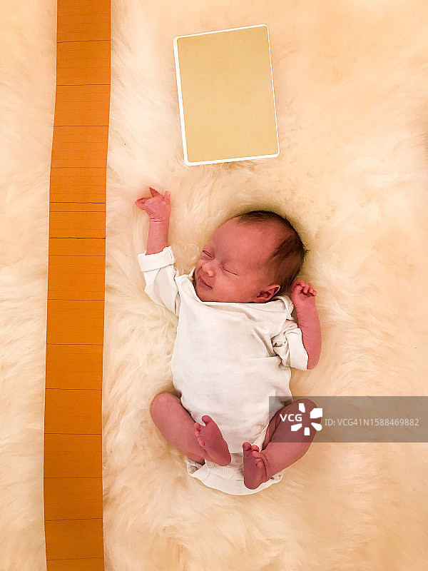 躺在柔软地毯上的新生儿图片素材