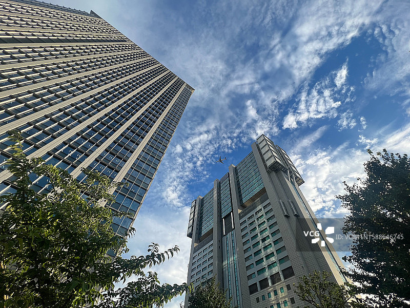 天空中飞机与办公楼的仰视角度图片素材